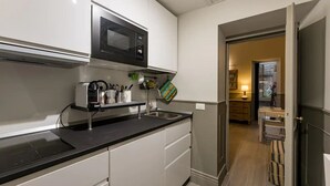 A modern kitchen with a built-in microwave, a coffee machine, and a sink.