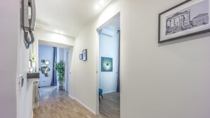A hallway with wooden flooring, a potted plant, and a framed picture on the wall. - Boutique Flaminio   150 m from Piazza del Popolo (ROMA)