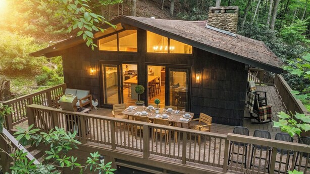 A wooden cabin with a deck, dining area, and large windows. - Penny Creek Cabin 2 bed 1 bath sleeps 6,Creekside*Hike*Fish*RELAX (Deep Gap)