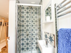 A bathroom with a shower, a sink, and a mirror. - Daisy Tree Cottage (Woodhall Spa)