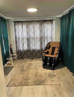 Relax in comfort with a massage chair, a cozy bench, and a light rug.