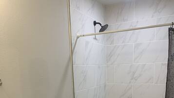 A bathroom with a shower, toilet, and sink.