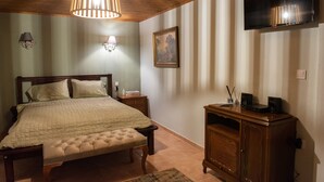 A bedroom with a bed, bedside tables, a wooden dresser, a TV, and a hanging light fixture. - DandyVillas Tsagkarada | Sweet Green Apple | Mini Pool (Tsagkarada)