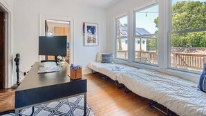 A room with a bed, a desk with a computer, and large windows. - Spacious 2/2 Home Prime Location Mins to DT/SOCO & SXSW Top Spots (Austin)