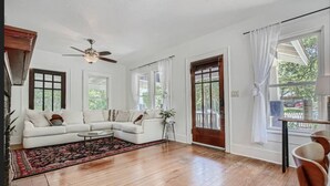 A spacious living room with a white sectional sofa, a wooden floor, and large windows. - Spacious 2/2 Home Prime Location Mins to DT/SOCO & SXSW Top Spots (Austin)