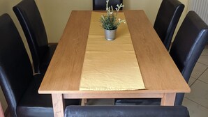 A dining table with a potted plant, black chairs, and a framed picture on the wall. - Club Unicum Apartman (Hévíz)