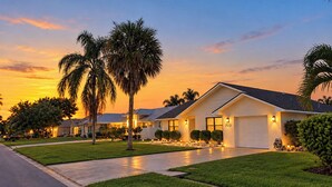 A residential house with a well-maintained lawn, a garage, and a driveway. - Centrally located 4/2 Home with a private backyard available for Longer Stays! (Port St. Lucie)
