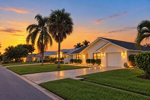 A residential house with a well-maintained lawn, a garage, and a driveway. - Centrally located 4/2 Home with a private backyard available for Longer Stays! (Port St. Lucie)
