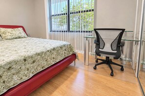 Une chambre à coucher avec un lit, un bureau et une chaise.