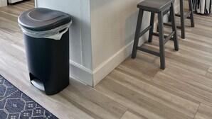A modern kitchen with a central island, white cabinets, a black trash bin, and a coffee maker. - ISLAND CLUB- East End OCEANFRONT Ground Level unit with gazebo and OCEAN VIEW (St. George Island)