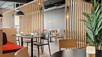 A modern restaurant with wooden partitions, black and wooden tables, and chairs.