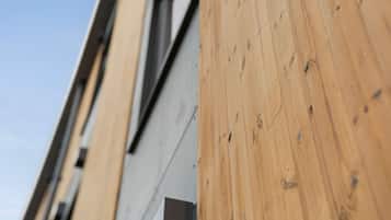 Primer plano de una pared de madera con veta y nudos bien visibles, que sugiere un material natural.