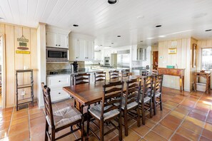 A spacious kitchen with white cabinets, a large wooden dining table, and multiple chairs. - 41 South Beach Lagoon at The Sea Pines Resort (Hilton Head Island)