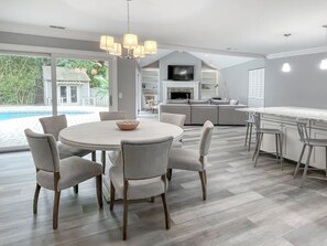 A modern kitchen with a dining area, a TV, and a fireplace. - 42 Planters Wood Drive at The Sea Pines Resort (Hilton Head Island)