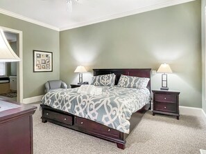 A neatly arranged bedroom with a large bed, two bedside tables with lamps, a chair, and a desk. - 90 Shell Ring Road at The Sea Pines Resort (Hilton Head Island)