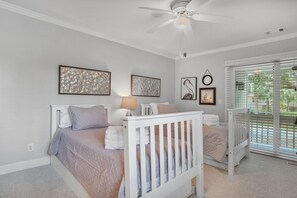 A bedroom with two beds, a ceiling fan, and artwork on the walls. - 1261 Harbour Town Club at The Sea Pines Resort (Hilton Head Island)