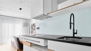 A modern kitchen with a black faucet, white cabinets, and a wooden countertop. - Livisit bergpartment 32 - double room 27 sqm - with kitchenette and bathroom (Stuttgart)