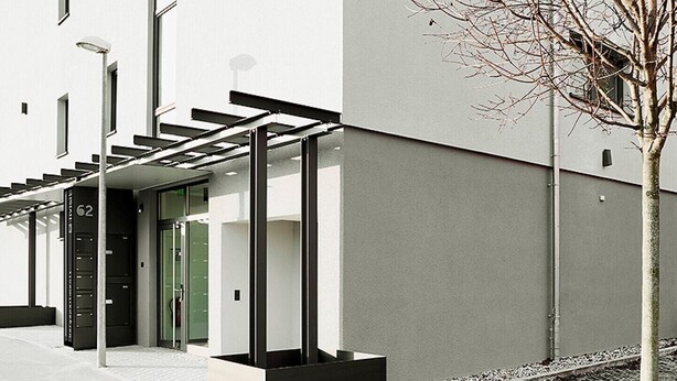 A modern building with a clean facade, a green door, and a small tree in the foreground. - Livisit bergpartment 32 - double room 27 sqm - with kitchenette and bathroom (Stuttgart)