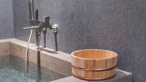 A wooden bowl with a copper band on a stone ledge by a pool. - Daisy Hotel (Yangpyeong)