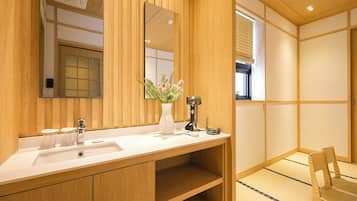 Un baño de madera con un espejo grande, un lavabo, un tocador y una silla.