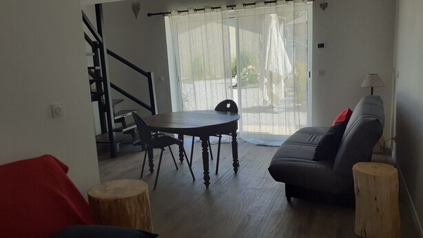 En stue med et træspisebord, en sofa og en trappe.