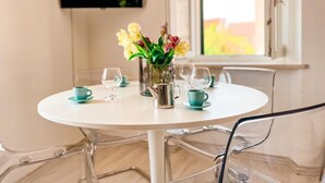 A round white table with a glass pitcher, two cups, and a vase with flowers. - Central Apartment Bol (Bol)