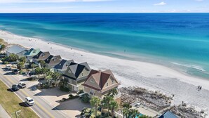 Une propriété située en bord de mer, comprenant plusieurs maisons, une route et une plage.