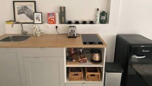 A compact kitchen with a sink, a toaster, and a refrigerator.