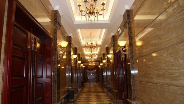 A long, narrow hallway with a checkered floor, wooden doors, and chandeliers. - Nanbu Shengzhong Lake Holiday Homestay (Nanbu County)