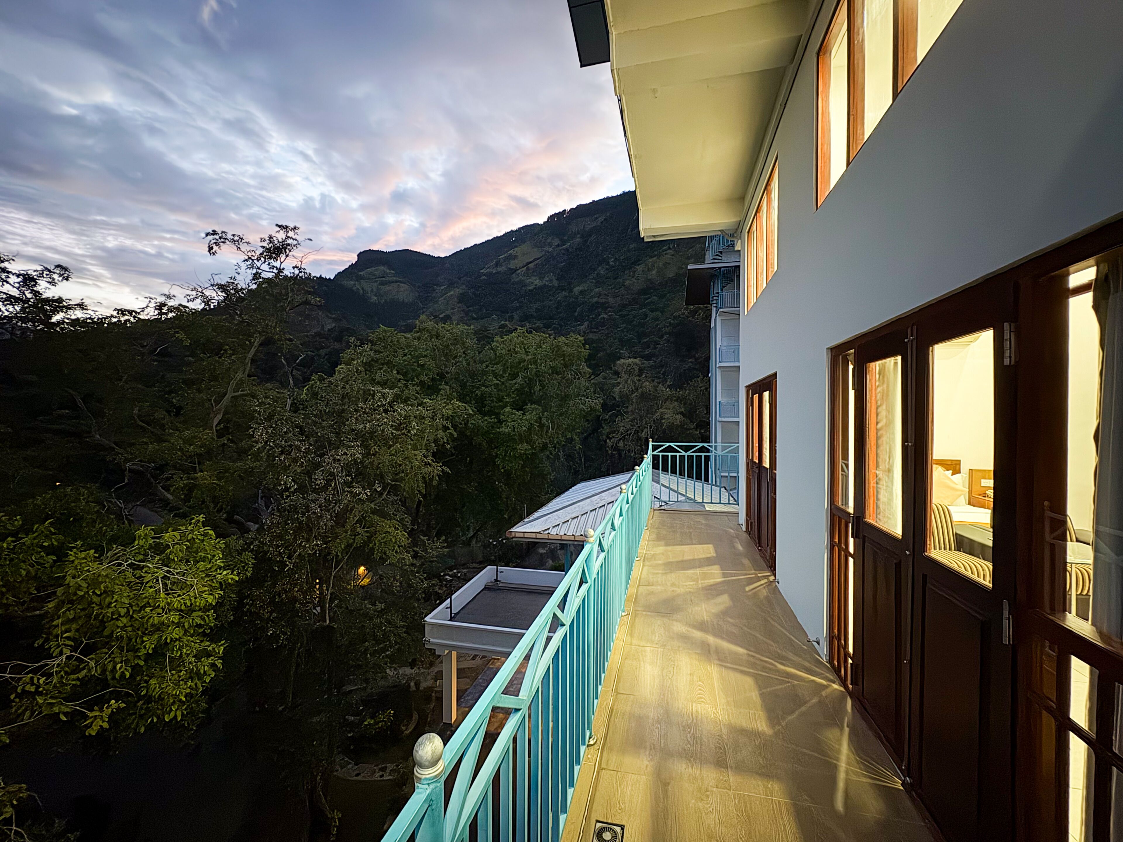 A hotel with a balcony overlooking a mountainous landscape.