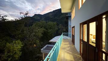 A hotel with a balcony overlooking a mountainous landscape.
