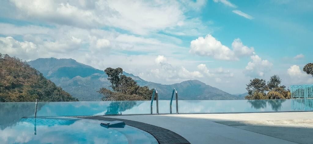 Une piscine aux eaux cristallines, offrant une vue sur les montagnes et les arbres.