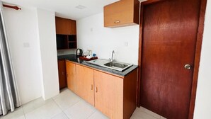 Una cocina compacta con armarios de madera, un lavamanos y una encimera.