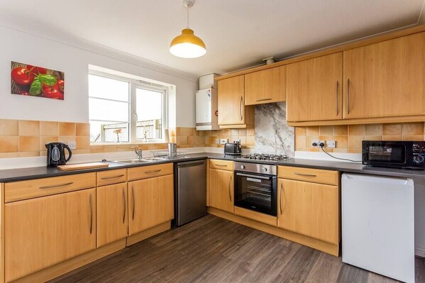 Enjoy cooking in this well-equipped kitchen with a sink, stove, oven, and microwave.
