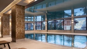 A spacious indoor swimming pool with large windows and a modern design.