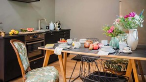 A modern kitchen with a dining table set for four, a sink, and a stove. - Cozy mountain loft - 15 minutes from Garmisch (Oberau)