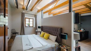 A bedroom with a large bed, a nightstand, a lamp, and a window with curtains. - Cozy mountain loft - 15 minutes from Garmisch (Oberau)