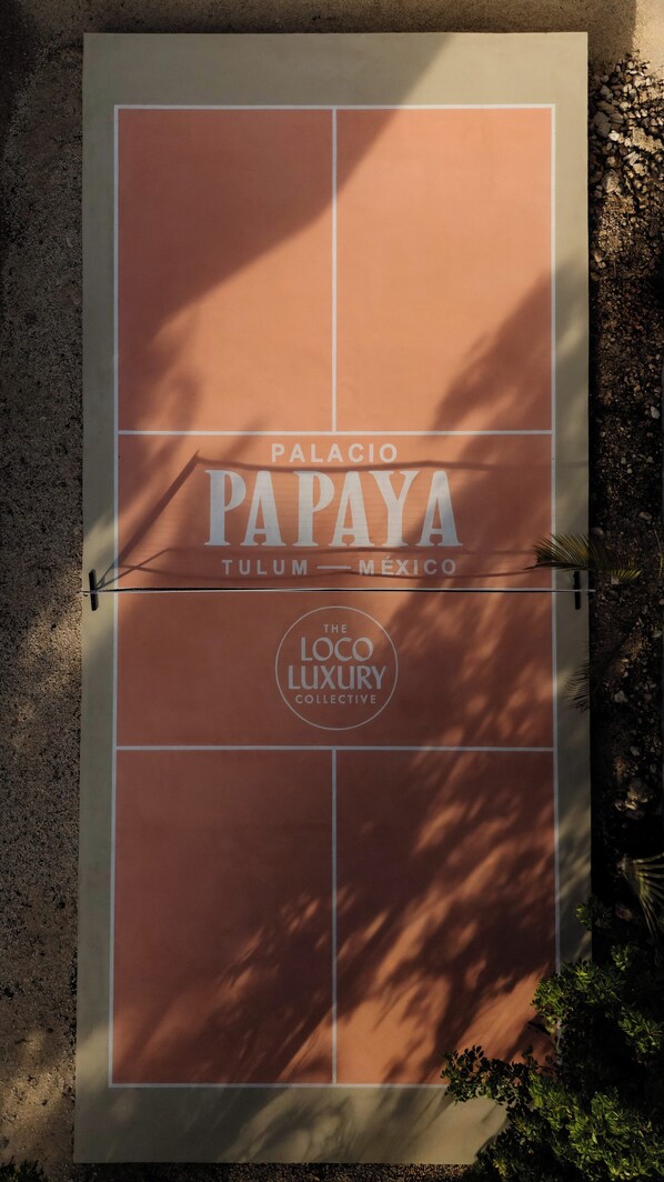 A sign for "Palacio Papaya Tulum - Mexico" with "The Loco Luxury Collective" branding.