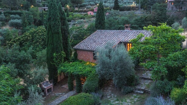 A rustic house surrounded by lush greenery and stone pathways. - Casa di Pan 6, Emma Villas (Panicale)