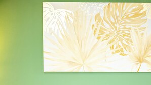 A bed with white linens, a green wall, and a floral artwork above the bed. - VALPOLICELLA APARTMENTS: OLIVE TREE RESIDENCE (Valgatara)