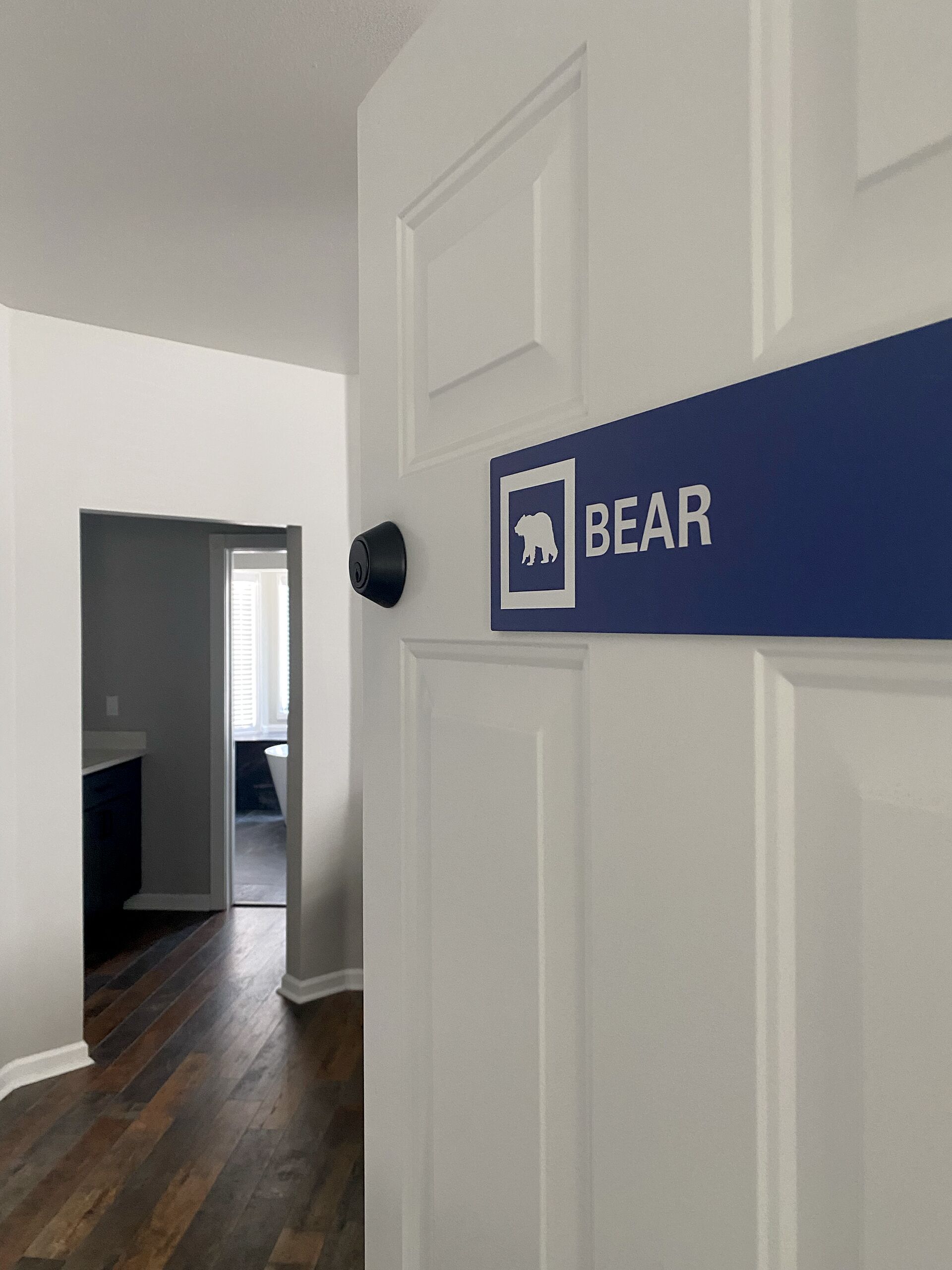 Un pasillo con una puerta que dice 'BEAR' y un timbre.