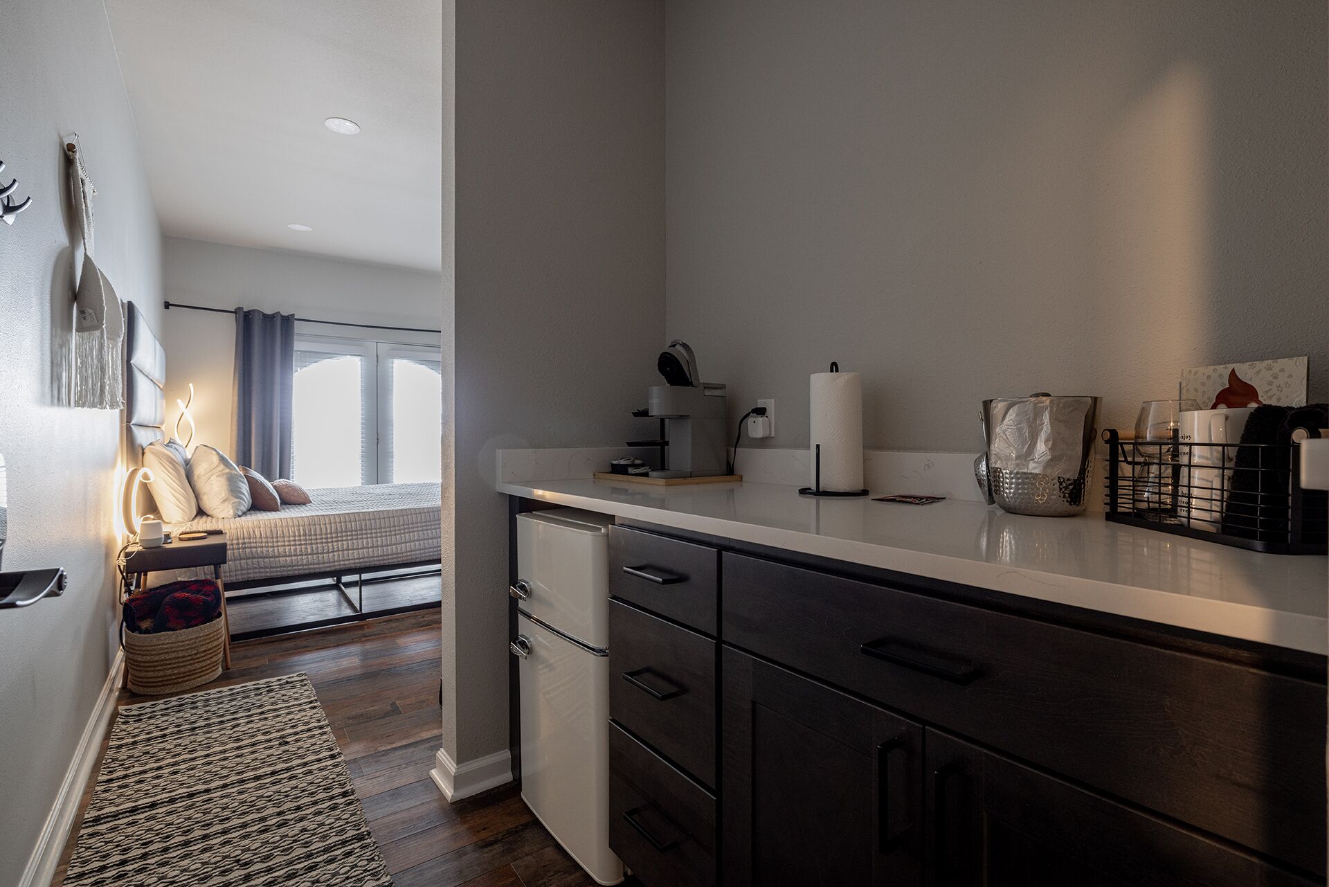 Une chambre à coucher moderne avec un lit, une table de chevet et une vue sur l’extérieur.