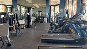 A gym with treadmills, weight machines, and dumbbells.