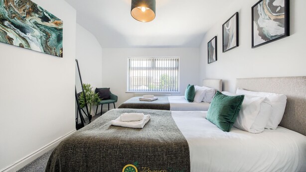 A hotel room with two beds, a large window, and artwork on the walls. - 52NRC Unli Wi-fi 3 Bedroom House (Coventry)