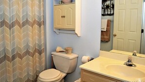 Een badkamer met toilet, wastafel en kast.