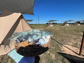 A tent with a basket of snacks and a clear sky.