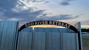 Une porte en bois sur laquelle on peut lire l’inscription « RED RIVER RETREAT ».