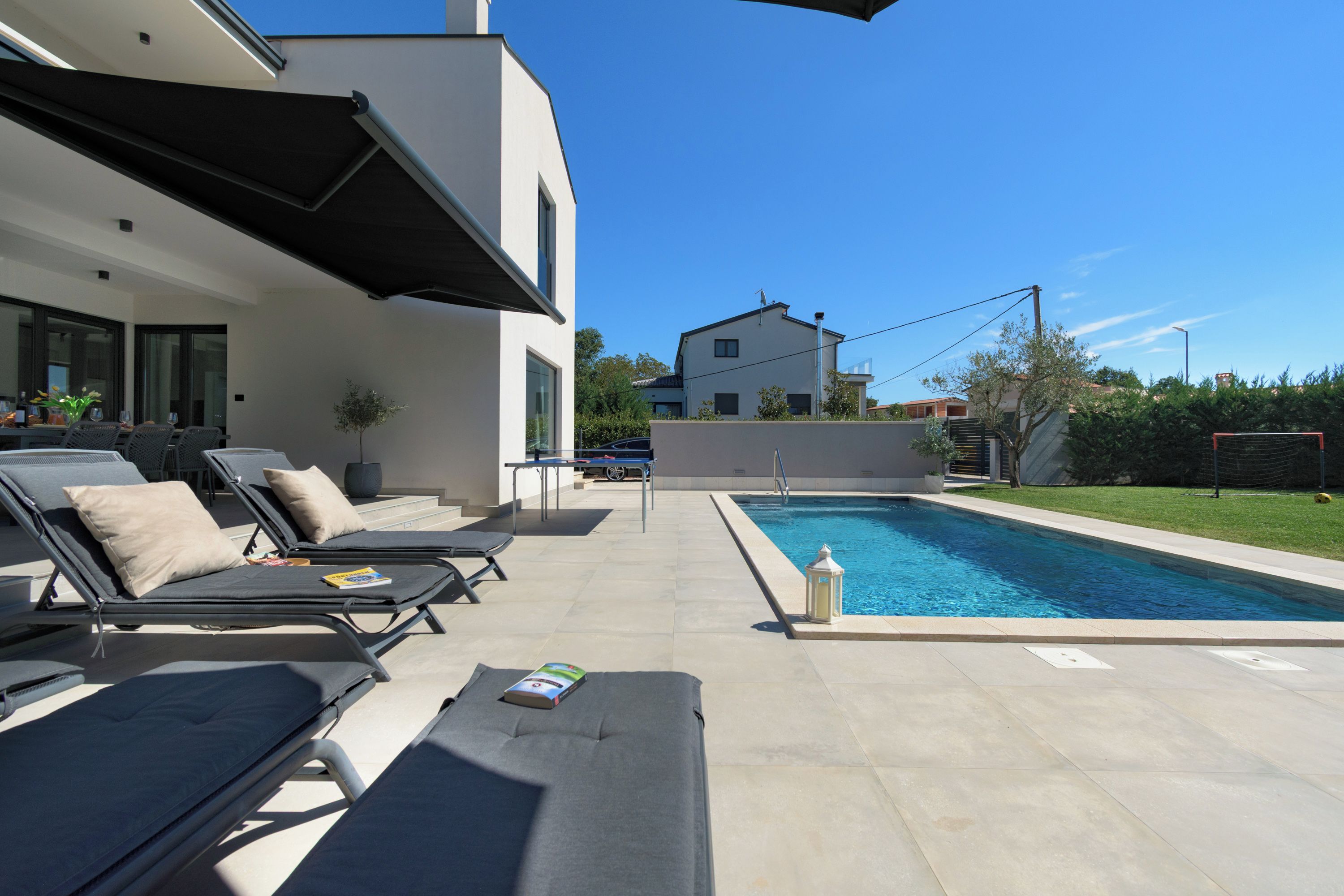 A modern outdoor pool area with lounge chairs and a swimming pool.