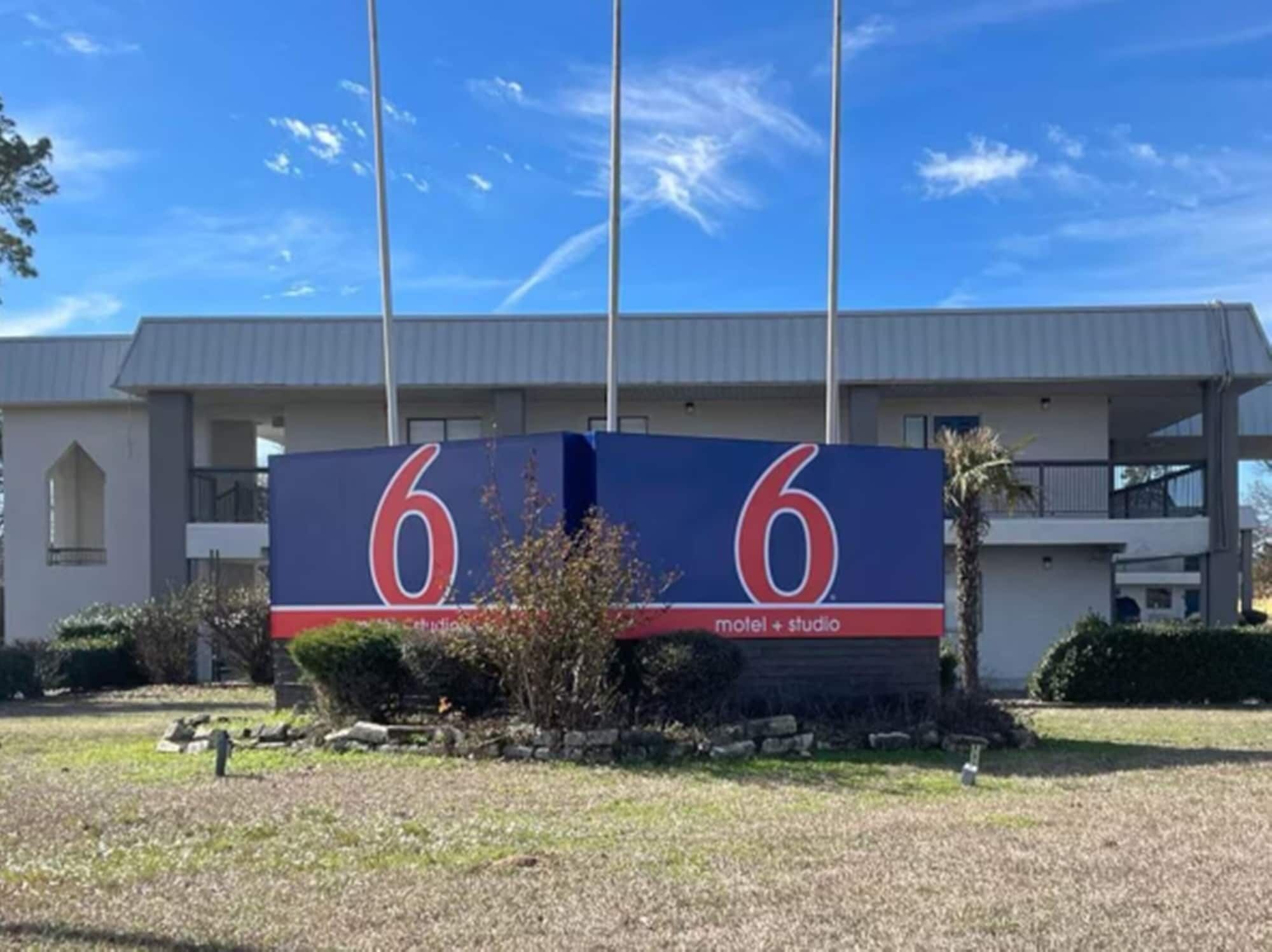 A motel with a large '6' sign, indicating it is the 6th motel in a series.