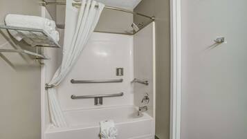 A modern bathroom with a walk-in shower, grab bars, a towel rack, and a shower curtain.